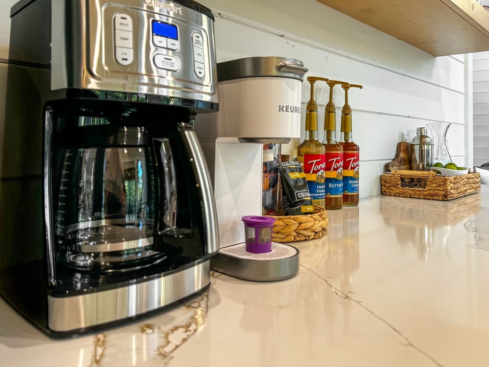Coffee bar with drip coffee pot or single serve Keurig, a selection of flavored syrups, and start up supply of sugar, creamer and coffee.  