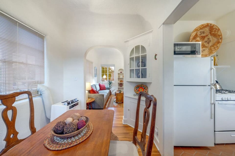 View of dining table for two, full-size fridge/freezer, microwave, and stove