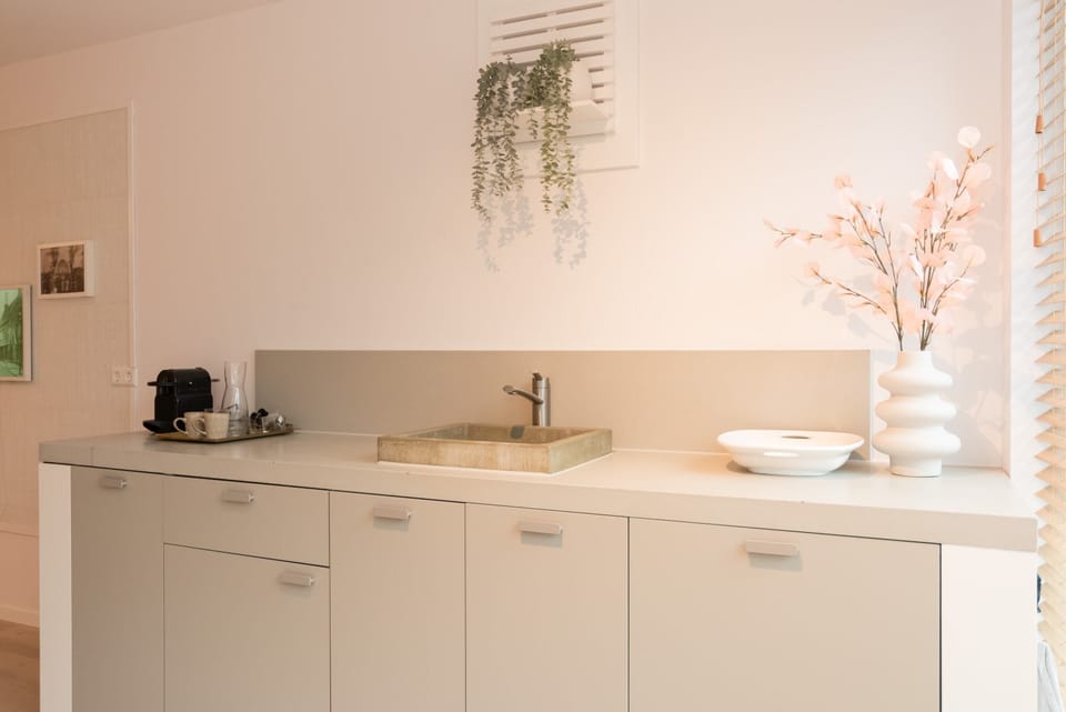 Minimalist kitchen equipped with Nespresso machine, sink and modern essentials — enjoy your coffee just the way you like it.

