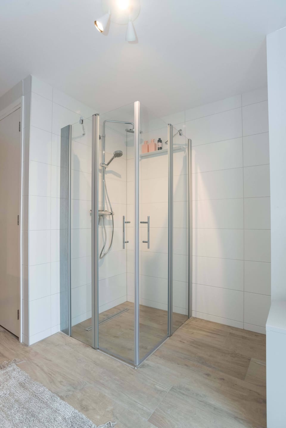 Spacious shower with glass doors and a rainfall head — start your day fresh and energized.