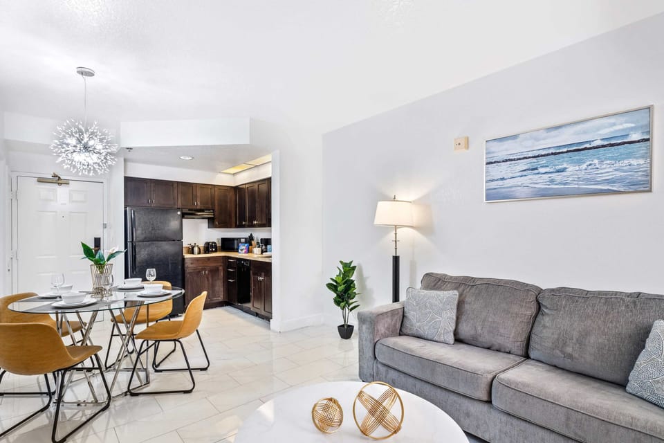 Living room with large smart TV, sleeper sofa and kitchen