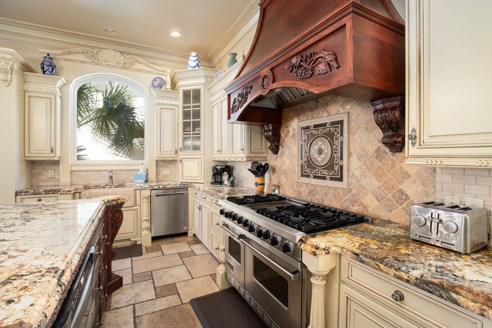 Step into your gourmet kitchen featuring marble countertops, professional appliances, and elegant carved details.