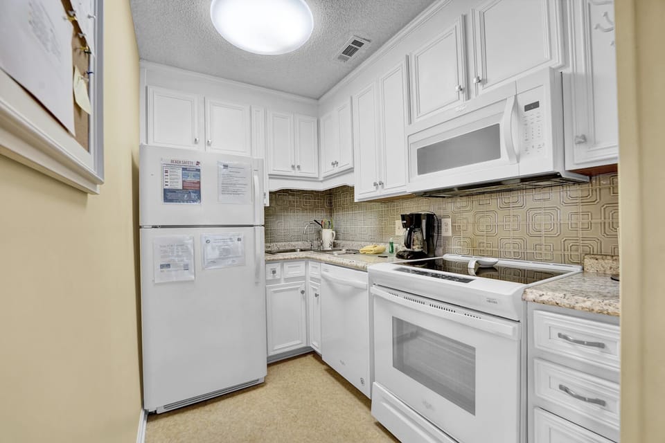 fully stocked kitchen with washer and dryer across the hall