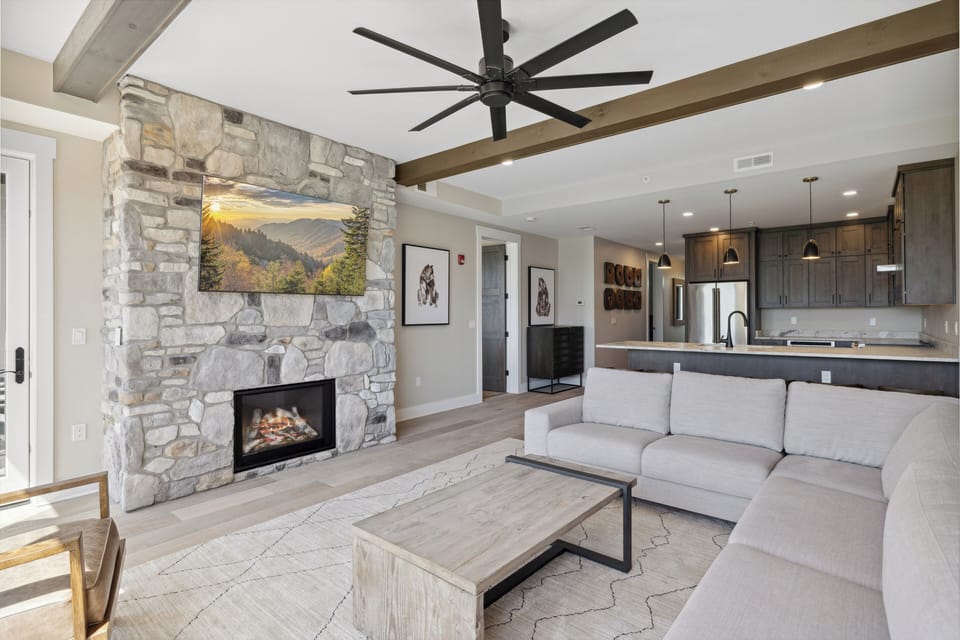 Spacious and Scenic Living Room with Stone Fireplace, Floor to Ceiling Windows with Smoky Mountain View, Smart TV's and WiFi throughout vacation condo