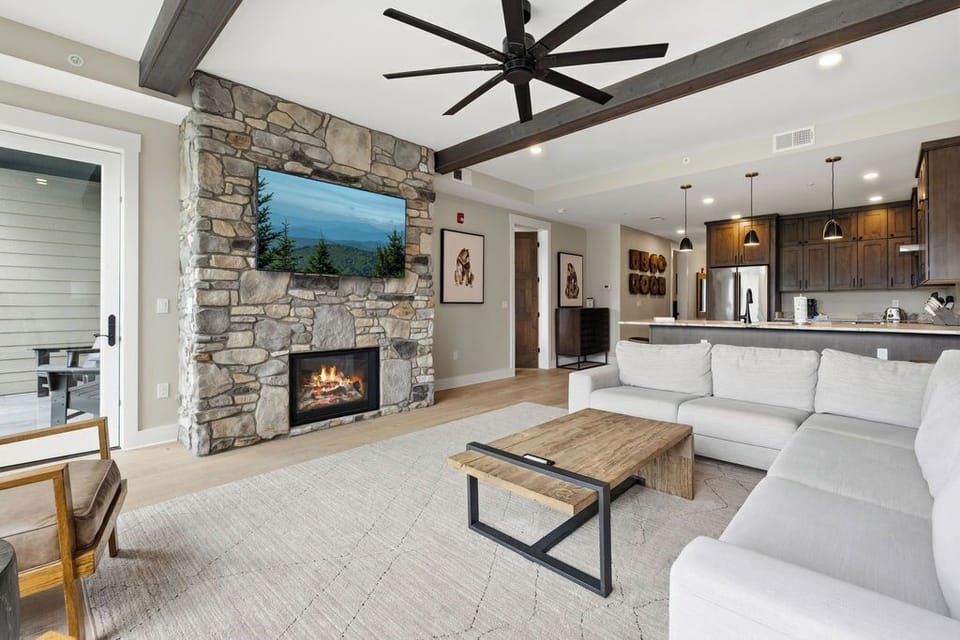 Spacious and Scenic Living Room with Stone Fireplace, Floor to Ceiling Windows with Smoky Mountain View, Smart TV's and WiFi throughout vacation condo