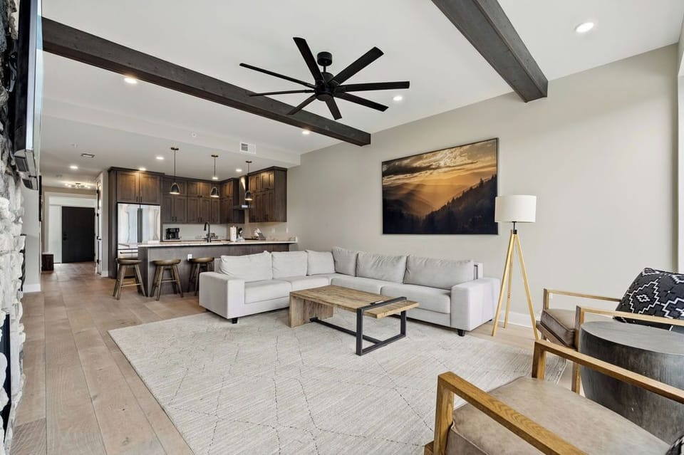 Spacious and Scenic Living Room with Stone Fireplace, Floor to Ceiling Windows with Smoky Mountain View, Smart TV's and WiFi throughout vacation condo