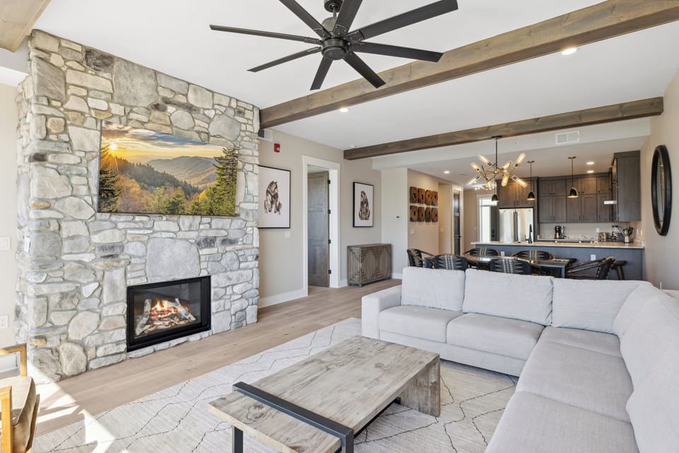 Spacious and Scenic Living Room with Stone Fireplace, Floor to Ceiling Windows with Smoky Mountain View, Smart TV's and WiFi throughout vacation condo