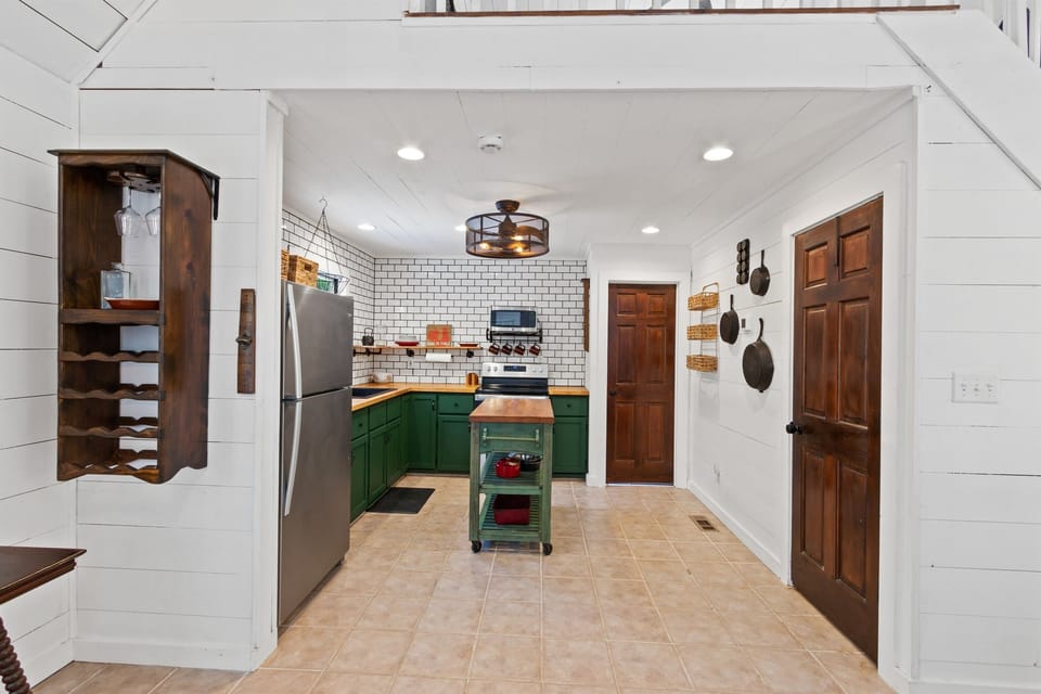 A bright kitchen featuring green lower cabinets, adding a pop of color and a fresh, modern touch to the space.