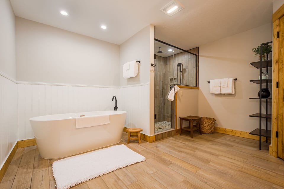 Main level primary bath with soaking tub and roomy tile shower.