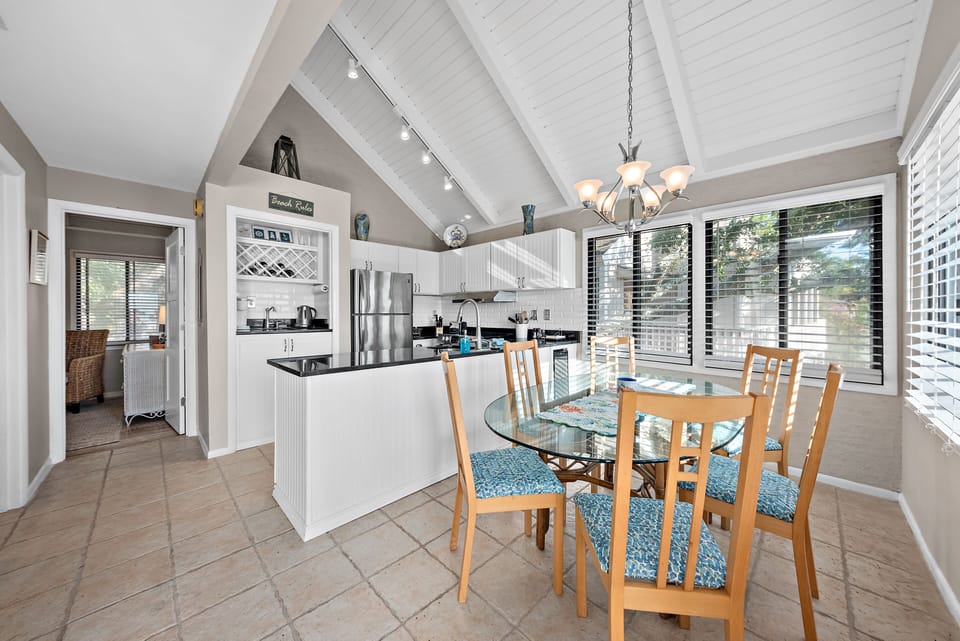 The dining table seats 6 and is surrounded by windows