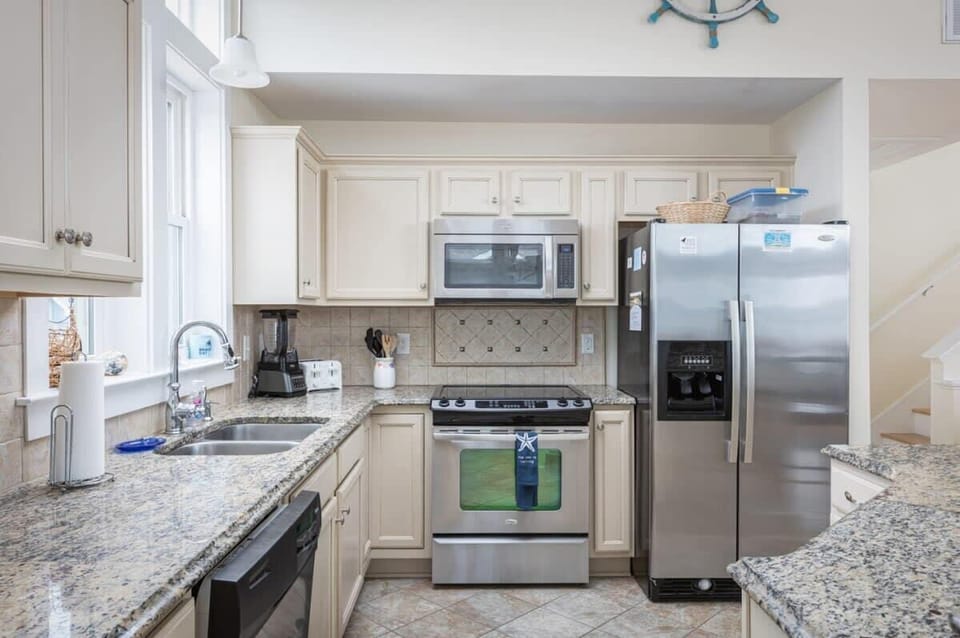 Fully Equipped Kitchen with a Refrigerator, Stove, Oven,Diswasher, Coffee Maker, Breakfast Bar Seating, and Tall Windows that Bring in Natural Daylight