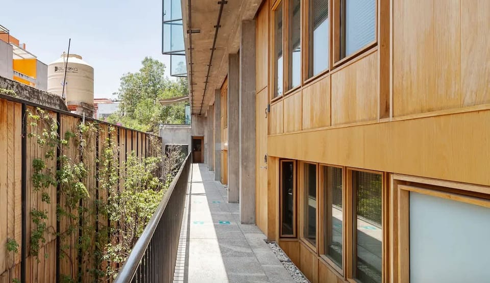 The building entrance features clean lines & bamboo greenery—a peaceful transition from the street.