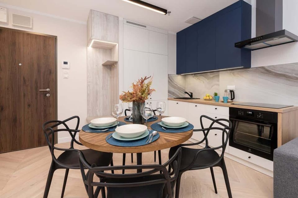 A different angle of the kitchen and dining area, highlighting the cohesive design with blue cabinets, white walls, and gold accents.







