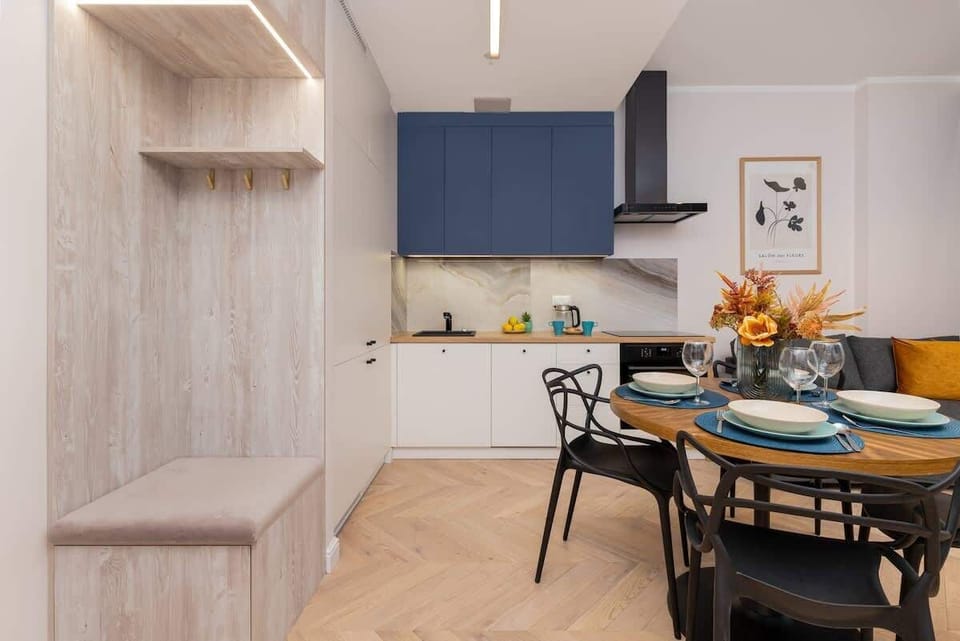 A cozy nook with a light wooden bench and a coat hanger, enhancing the apartment’s functional and stylish entryway.

