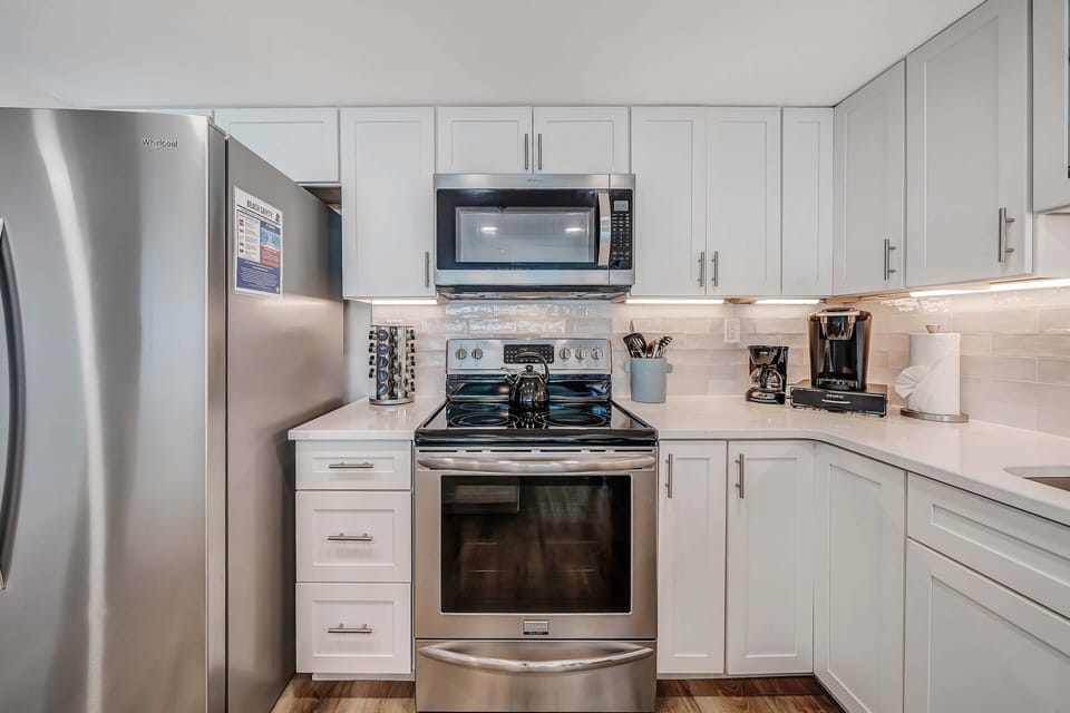 The beautifully updated, fully equipped kitchen features quartz countertops and stainless-steel appliances.