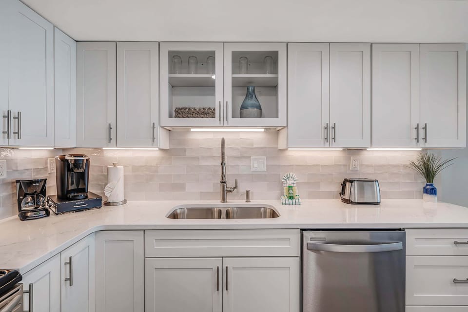The beautifully updated, fully equipped kitchen features quartz countertops and stainless-steel appliances.