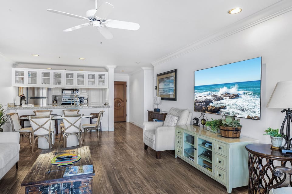 Relax in your bright coastal haven where the kitchen flows into your living space, perfect for entertaining while ocean waves dance on screen.