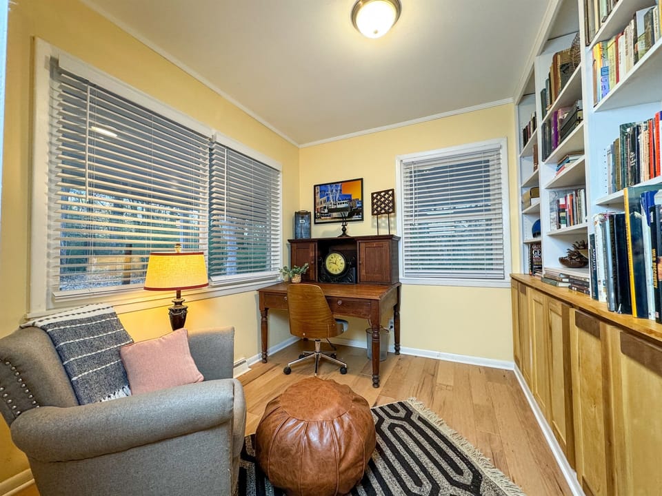 The office is adorned with a generous collection of books along its walls, offering the perfect backdrop for inspiration or leisurely reading sessions.