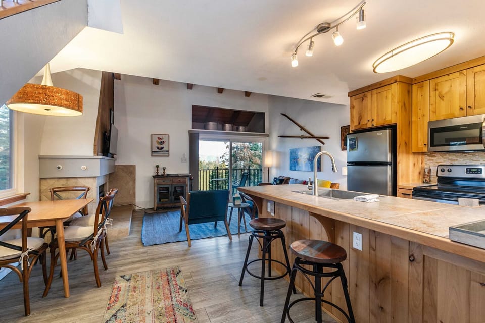 A cozy dining table with seating for four and a kitchen bar with 2 bar stools provides plenty of space to enjoy meals or catch up on remote work.