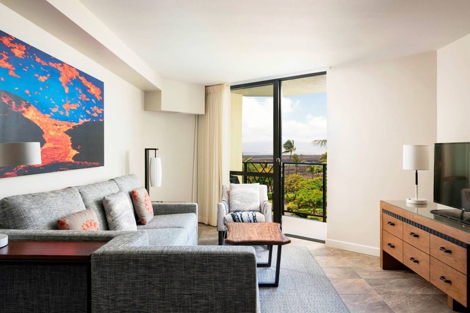 Separate living room features a sleeper sofa, TV, and door to another patio.