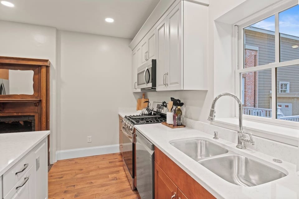 Unit #1 (1 of 3,  Ground Floor) Blend of classic and contemporary: Enjoy cooking in a fully updated kitchen with a charming historic fireplace. 