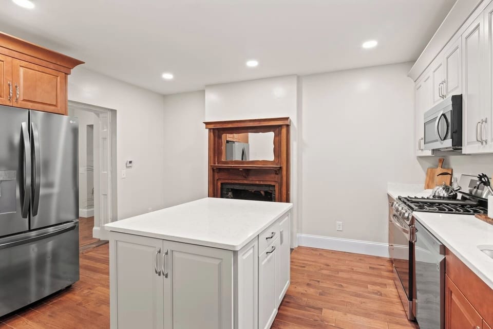 Unit #1 (1 of 3,  Ground Floor) Blend of classic and contemporary: Enjoy cooking in a fully updated kitchen with a charming historic fireplace. 