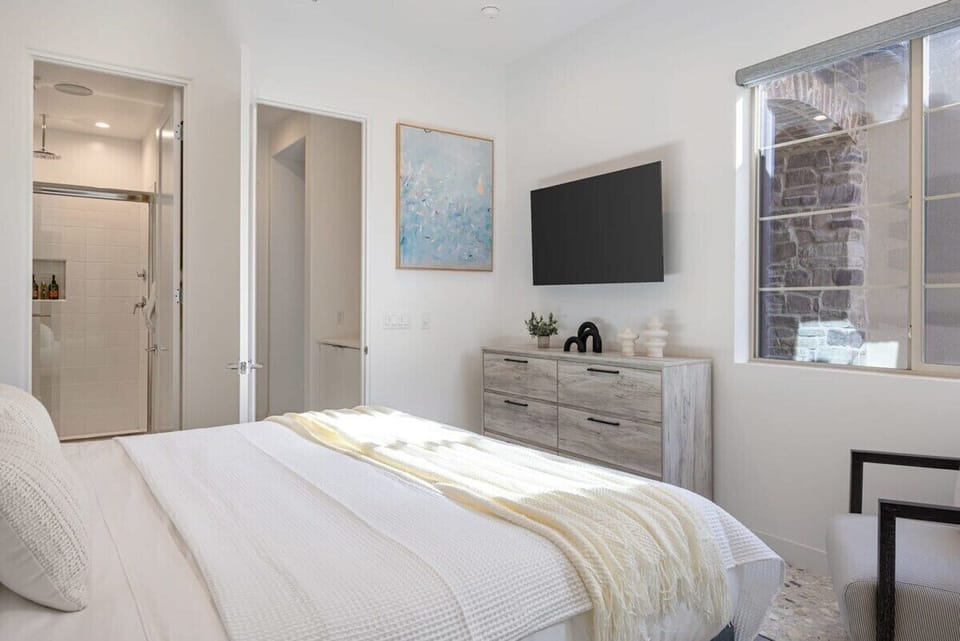 Comfortable bedroom with TV and dresser for a relaxing home away from home.