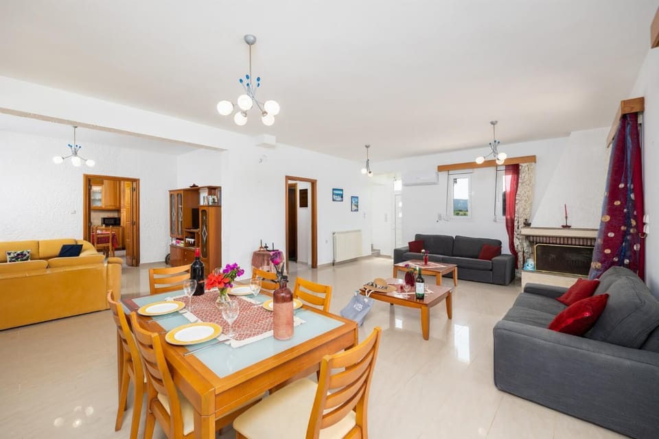 Living room with sofas, dining area, ornamental fireplace, A/C, WiFi internet, and satellite TV