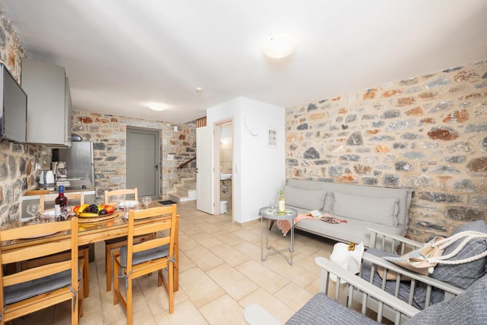 Open-plan living room with sofa, dining area, kitchen, A/C, WiFi internet, and satellite TV