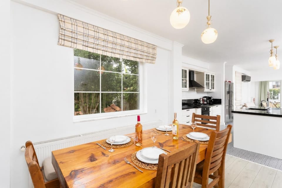 Open-plan living room with sofas, dining area, kitchen, A/C, WiFi internet, and satellite TV