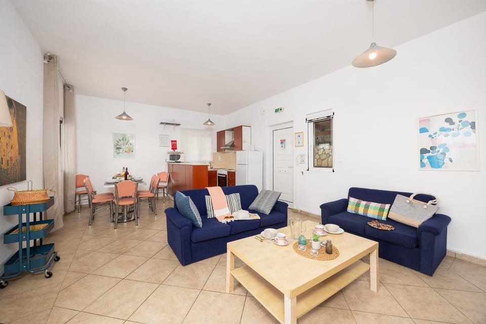 Open-plan living room with sofas, dining area, ornamental fireplace, WiFi internet, and satellite TV