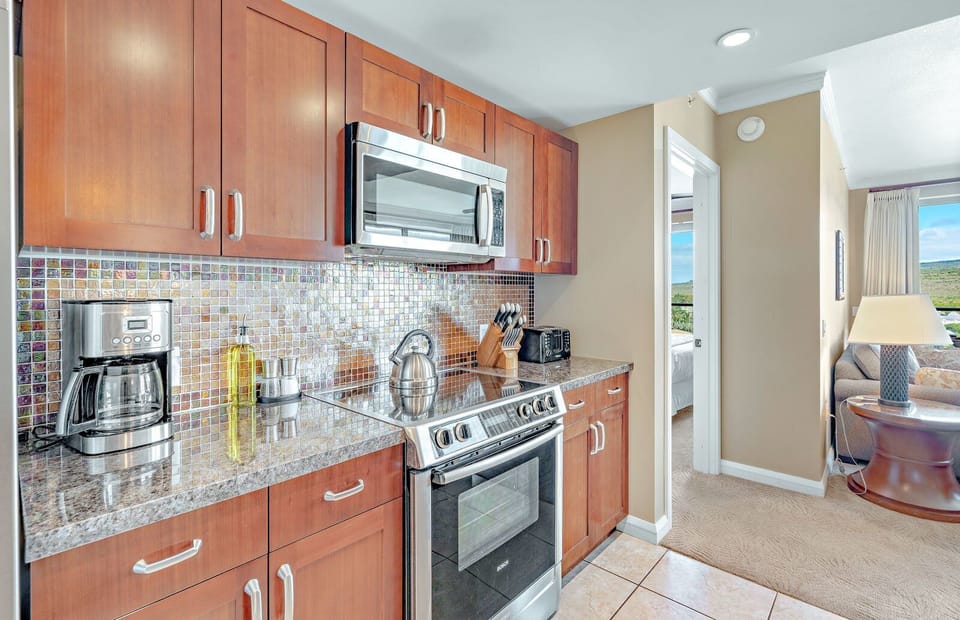 Stylish kitchen with mosaic backsplash, modern appliances, and cozy layout.