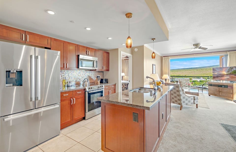 Sleek island kitchen flows into paradise views and cozy living space.