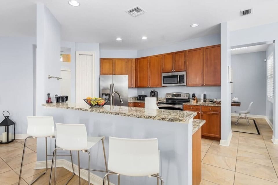 Modern kitchen with granite countertops and breakfast bar seating.