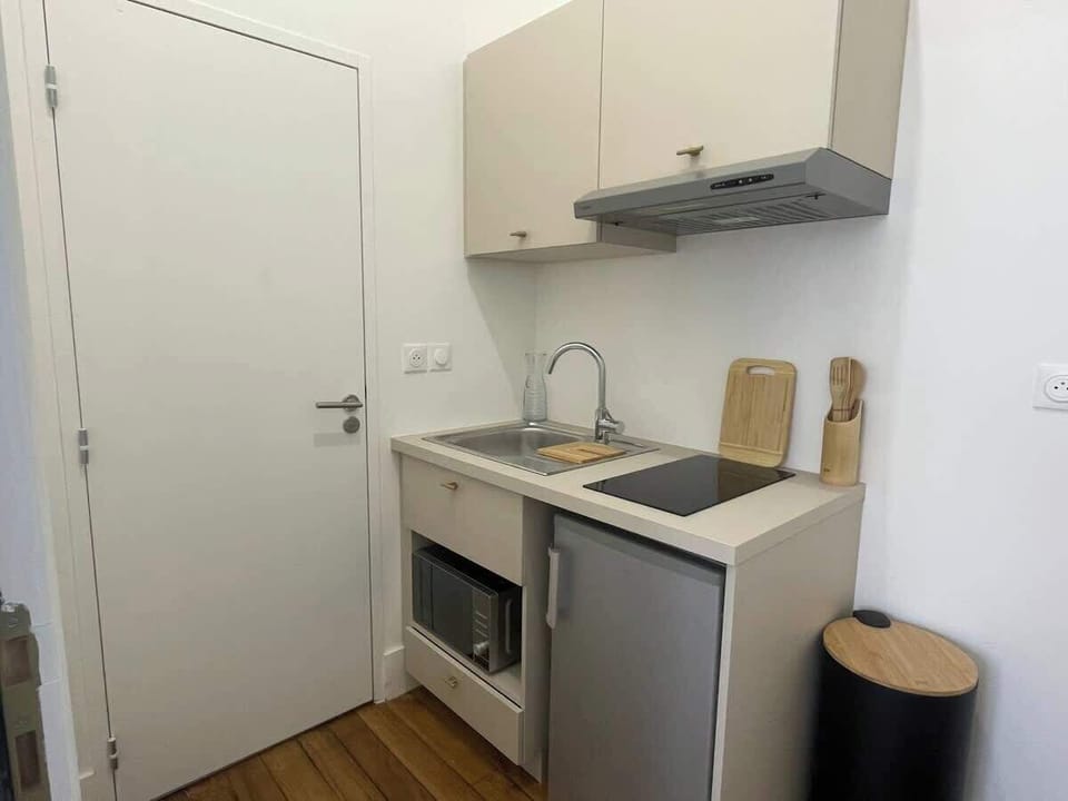 Cuisine avec micro-ondes, réfrigérateur, évier et placards hauts — coin repas complet du studio Le Chill proche gare Matabiau Toulouse