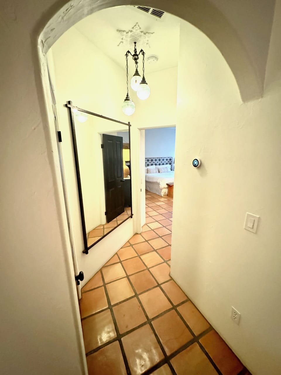 Hallway leading to Primary Bedroom. Nest thermostat.