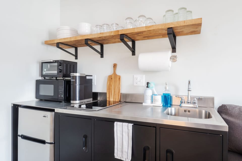 Fully equipped kitchenette with mini fridge, two burners, microwave, and toaster