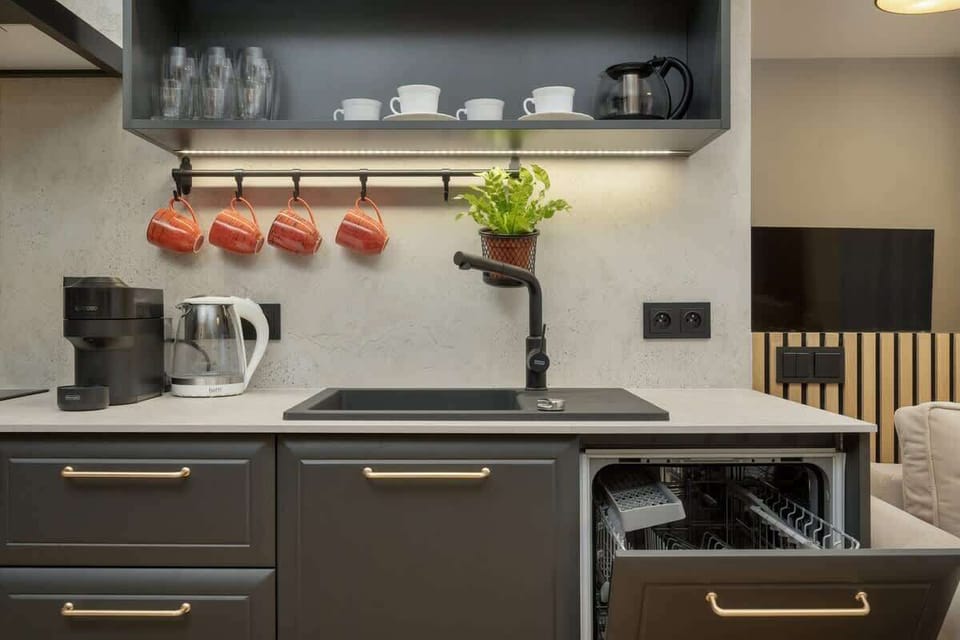 Another angle of the kitchen with matte black cabinetry, a built-in oven, and open shelving for functional, stylish storage.

