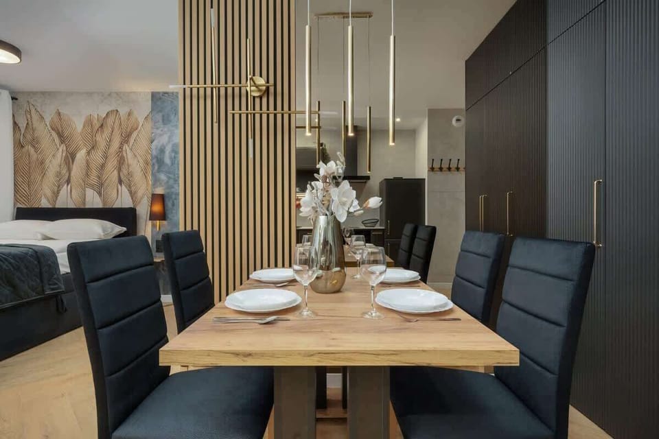 A different perspective of the dining and living area, highlighting the cohesive design, gold accents, and open layout.

