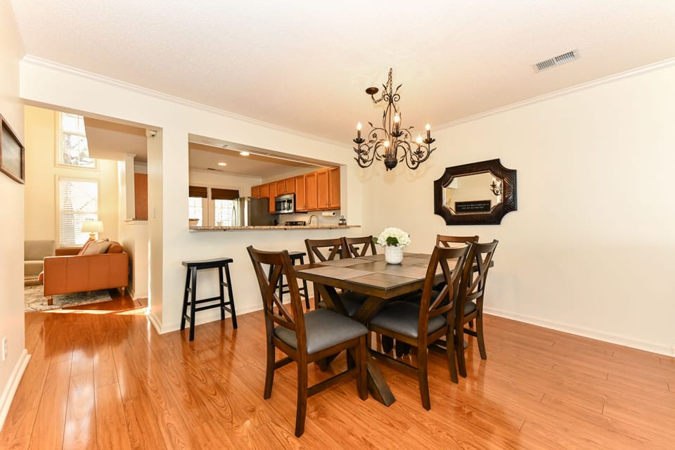 Dining area open to kitchen and living area. Bar sitting at kitchen counter.