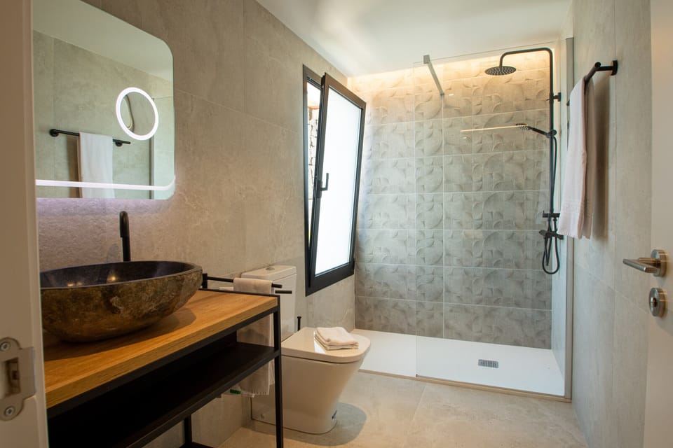 Revitalize yourself under a rain shower in a modern bathroom with impeccable finishes.