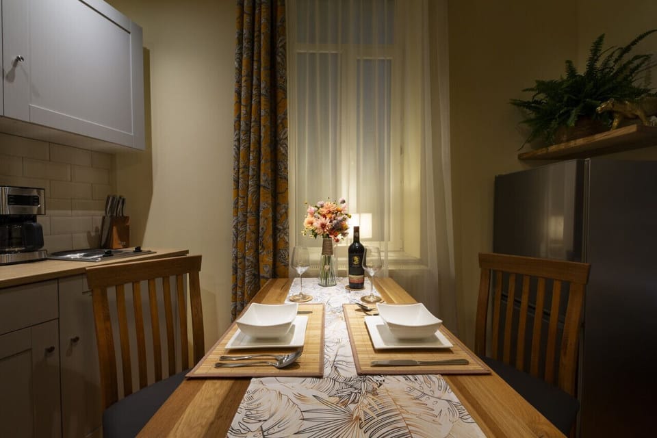 Inviting dining space, adorned with cozy lighting and lush plants, that creates a warm and welcoming atmosphere. The jungle decor adds a unique touch, making it an ideal spot to enjoy your meals.