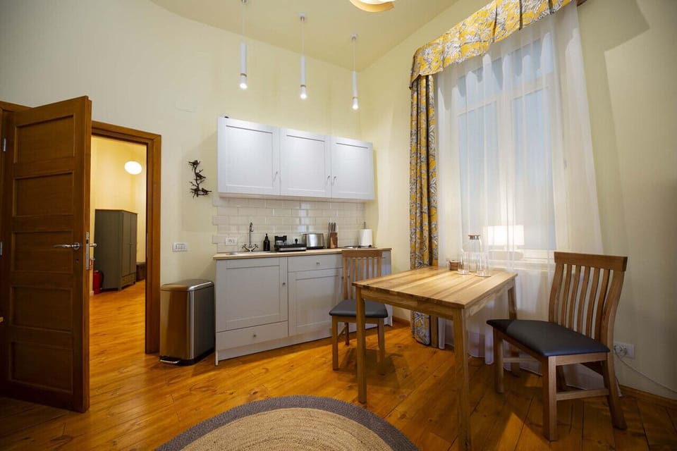 Spacious area with a fully equipped kitchen, dining section, and a view extending into the hallway