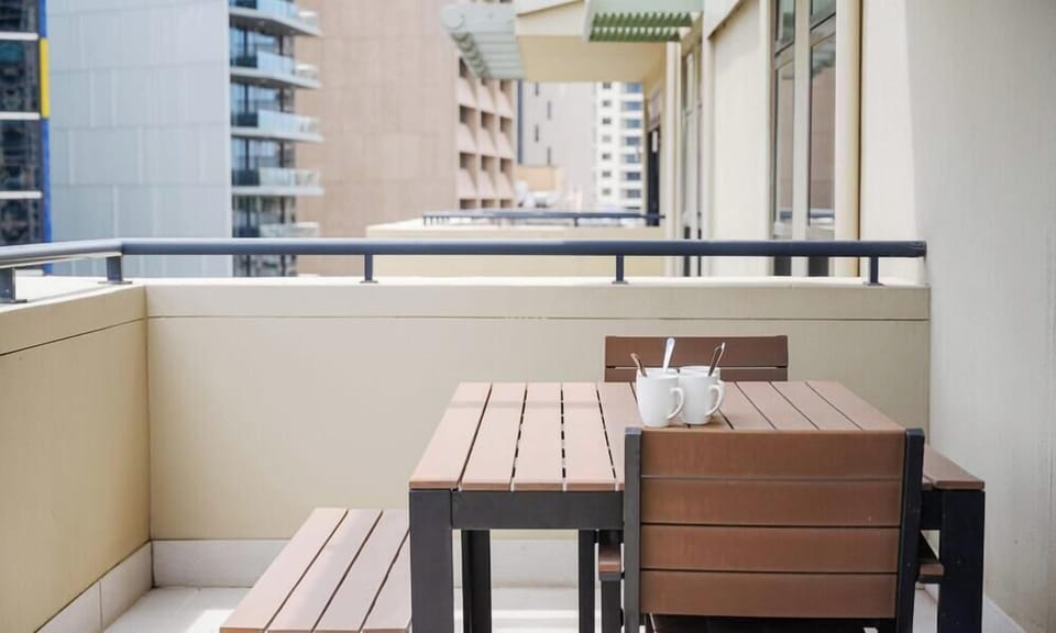 Private balcony with outdoor table and bench seating.