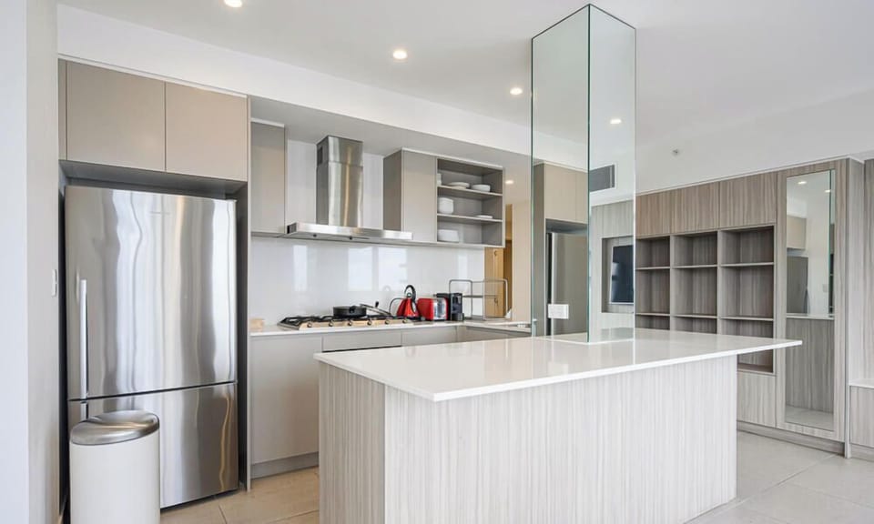 Kitchen with island bench, refrigerator, and open-plan layout.