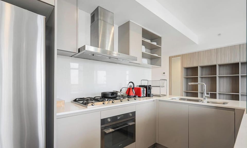 Fully equipped kitchen with stainless steel appliances, cooktop, oven, and ample cabinetry.