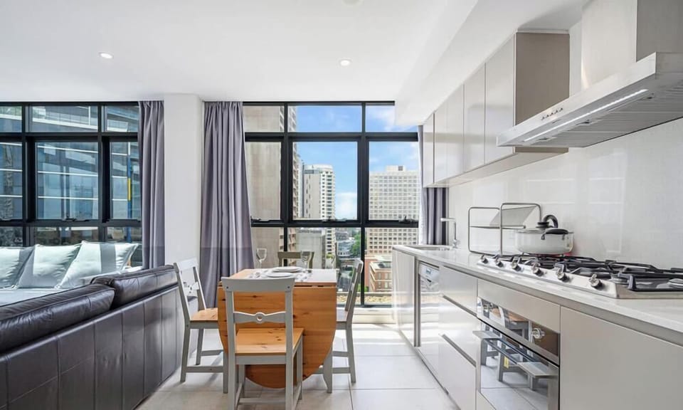 Kitchen and dining space with modern appliances, gas cooktop, and ample cabinetry.
