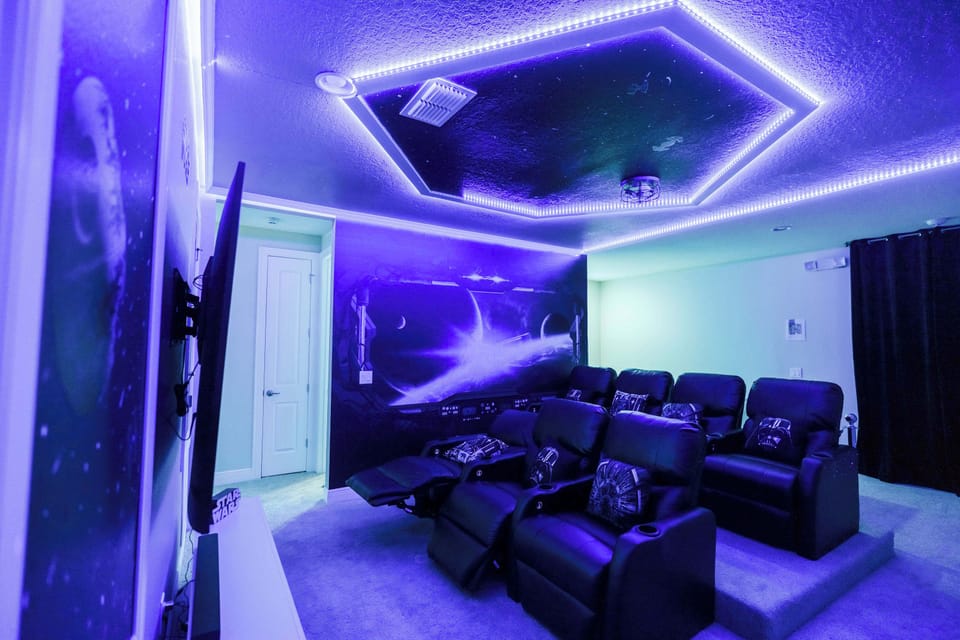 Experience cinematic thrills in your private sci-fi themed home theater with luxurious recliners and ambient lighting.