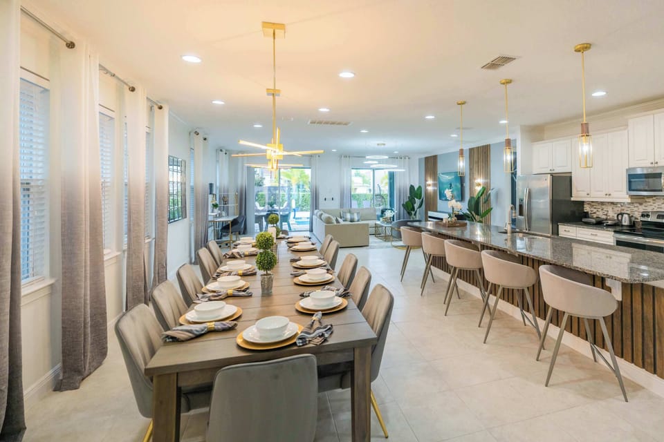 Elegant dining and kitchen area perfect for large gatherings, featuring modern decor and seamless indoor-outdoor flow.