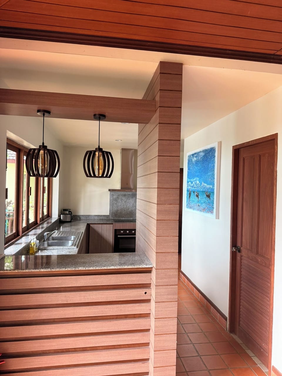 Modern kitchen with stylish pendant lighting and local art
